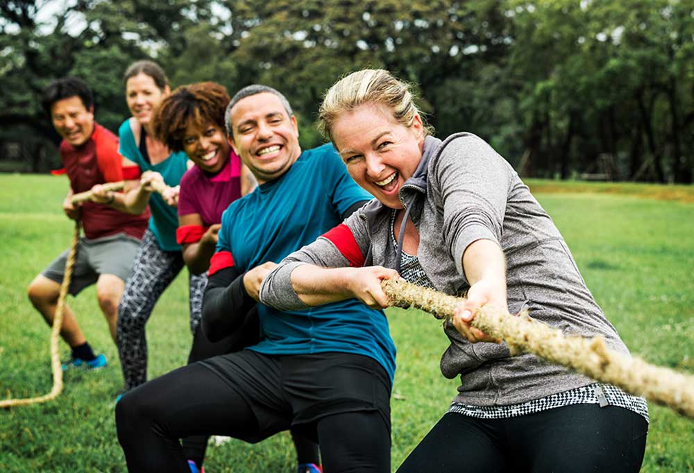 5 people playing game of tug o war